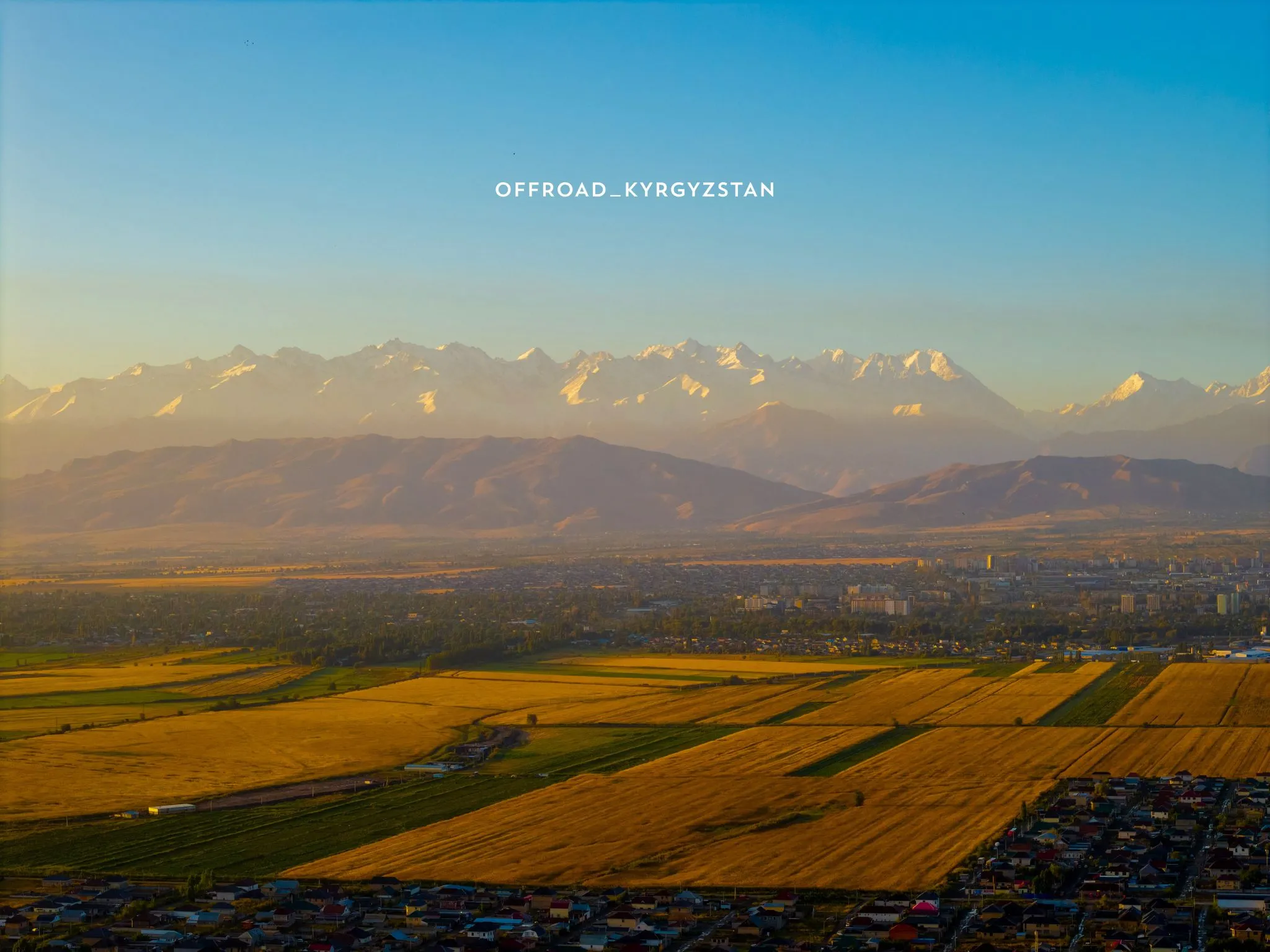 The starting point of our Kyrgyzstan expeditions: aerial view of Bishkek city and the surrounding snowy mountains.